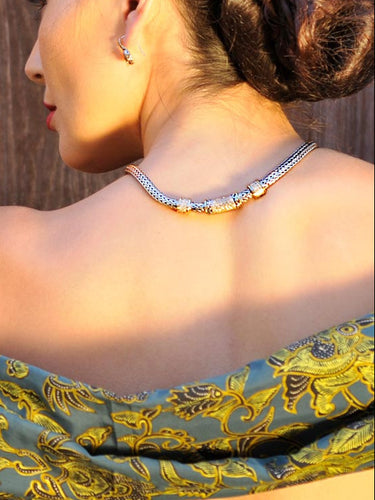 Woman in traditional attire against a textured wall